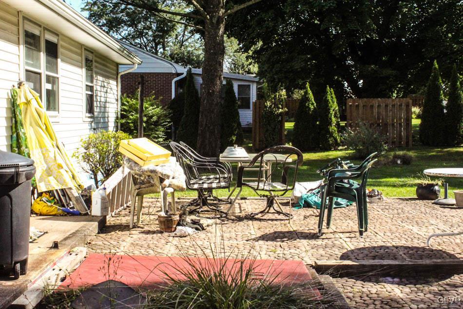 5916 Old Carriage Road Bath, PA 18014 - Photo 23 of 28 a view of a patio with table and chairs under an umbrella with large trees