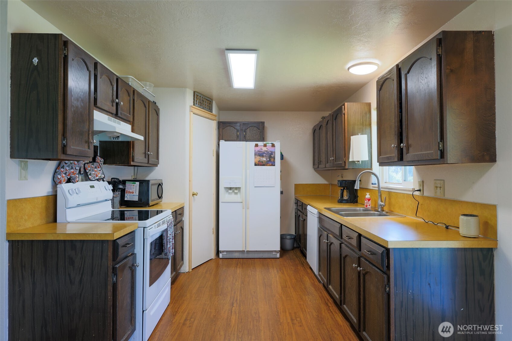 209 West Scott Street Aberdeen, WA 98520 - Photo 7 of 16 a kitchen with a sink stove and refrigerator