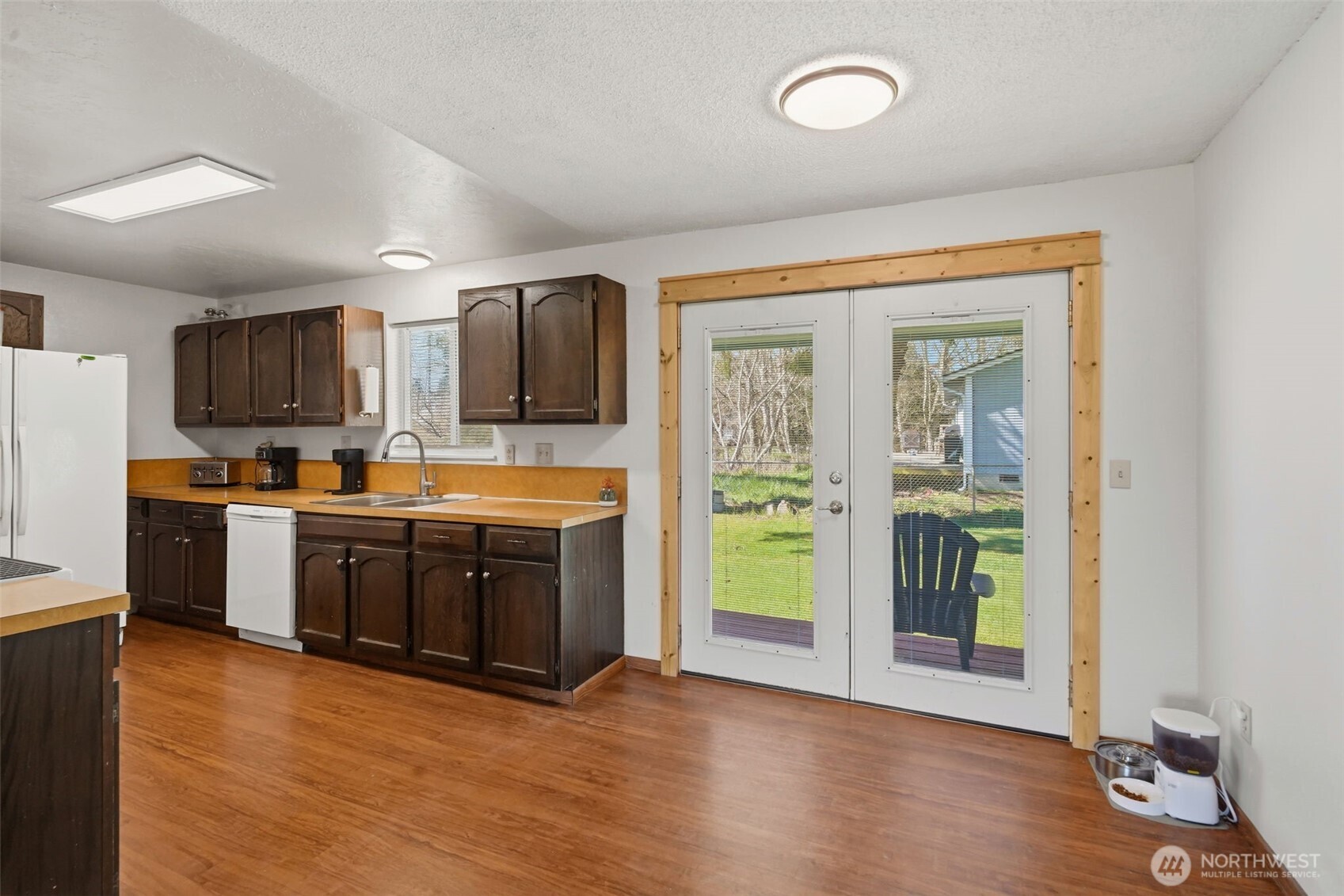 209 West Scott Street Aberdeen, WA 98520 - Photo 10 of 26 a kitchen with stainless steel appliances granite countertop a refrigerator a stove top oven and a sink with wooden floor