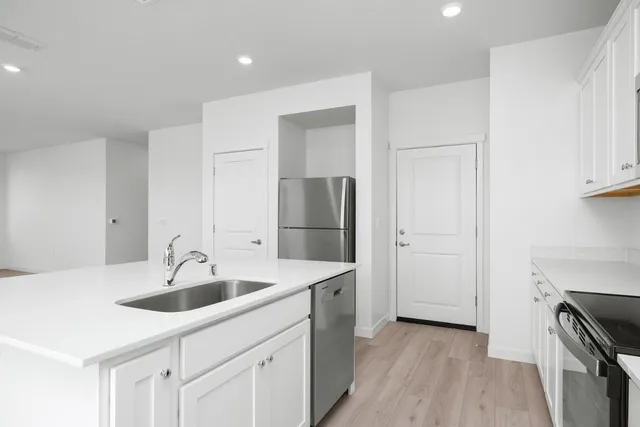 a kitchen with sink cabinets and stainless steel appliances