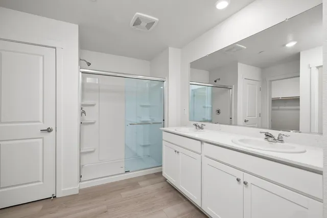 a bathroom with a shower sink and mirror