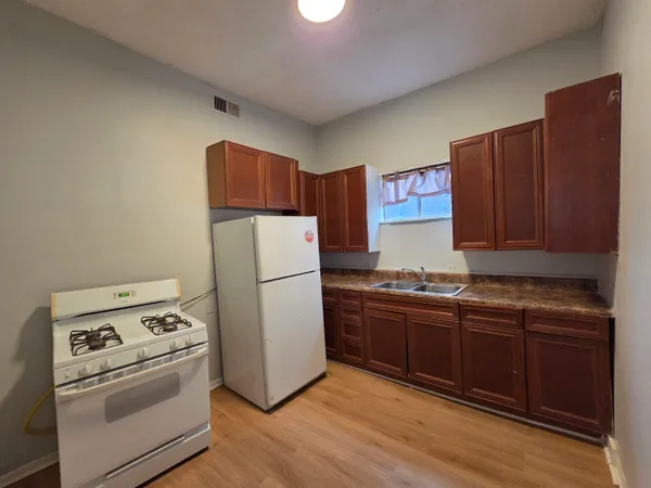 a white refrigerator freezer and a stove sitting inside of a kitchen