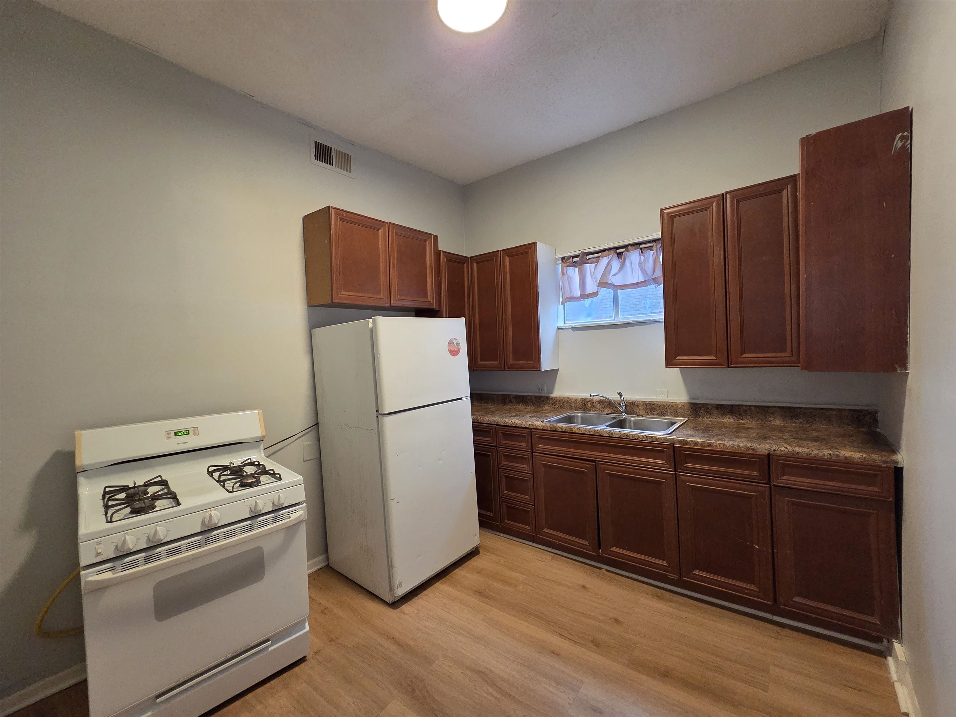 993 Oakview Street, Unit 101 Memphis, TN 38114 - Photo 9 of 14 a kitchen with wooden cabinets and white appliances