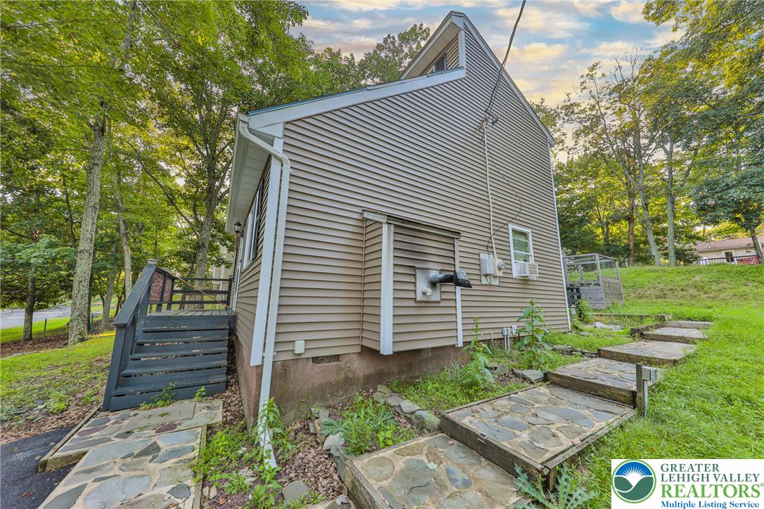 2114 Lakeview Road Bushkill, PA 18324 - Photo 80 of 83 Natural stone steps wind alongside the horizontal siding exterior of this wooded property.