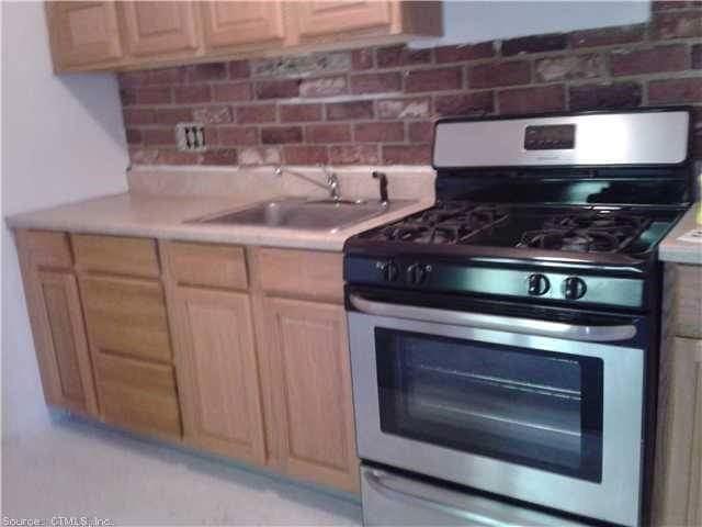 a stove top oven sitting inside of a kitchen