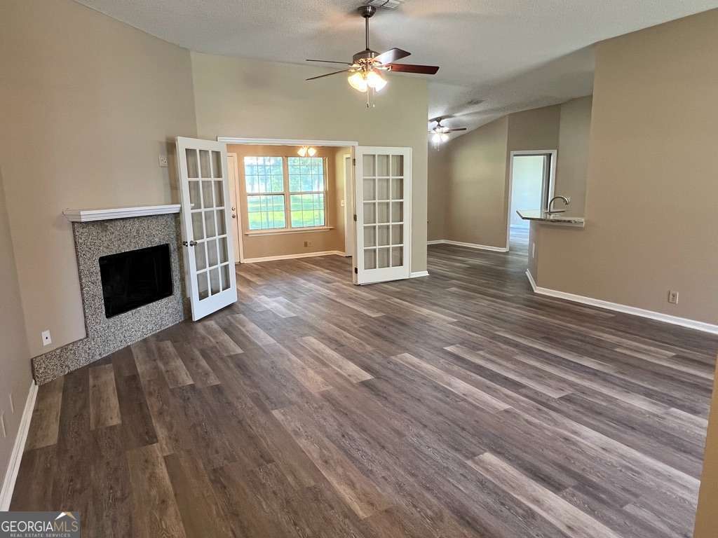 202 Thompson Court St. Marys, GA 31558 - Photo 2 of 15 a view of an empty room with wooden floor fireplace and a window