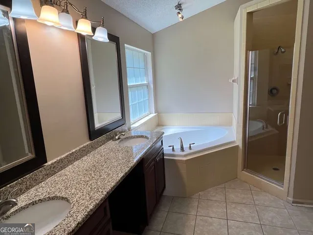 a bathroom with a granite countertop bathtub and shower