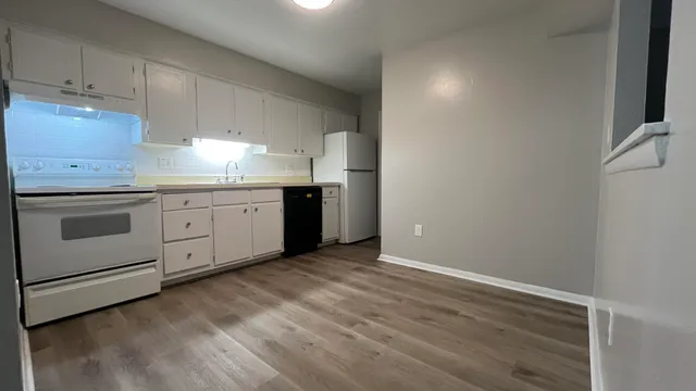 a kitchen with granite countertop white cabinets and white appliances