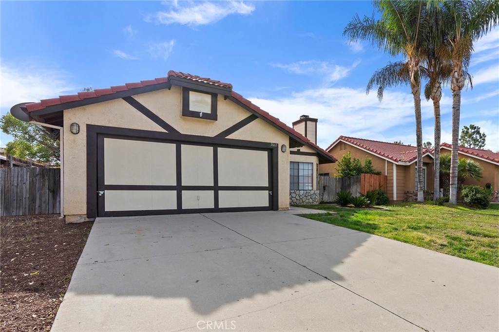 a front view of a house with a garden and trees