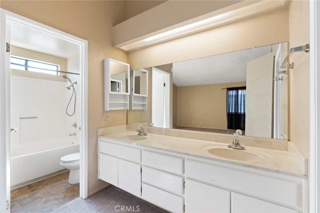 3665 Anchorage Street Hemet, CA 92545 - Photo 15 of 23 a bathroom with a granite countertop sink double mirror bathtub shower and a bathtub