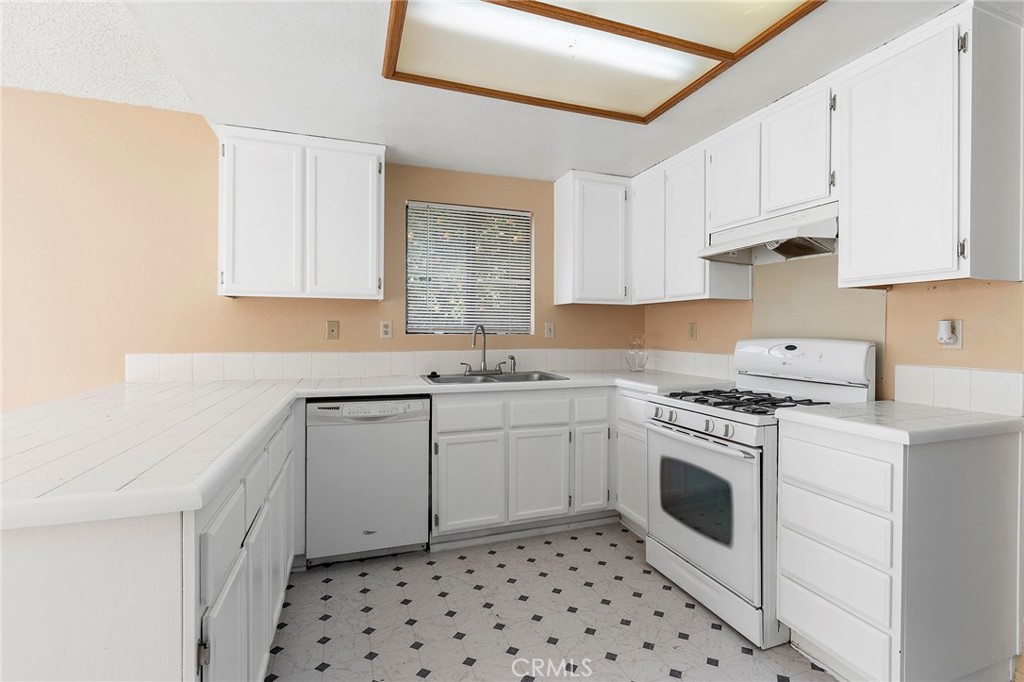 3665 Anchorage Street Hemet, CA 92545 - Photo 8 of 23 a kitchen with granite countertop cabinets a sink and white stainless steel appliances