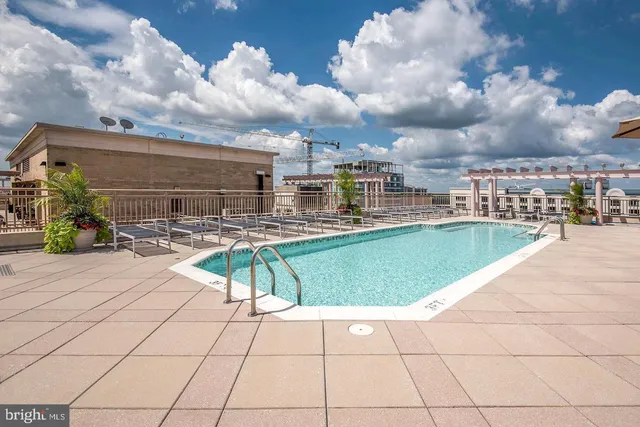 a swimming pool with outdoor seating and barbeque oven