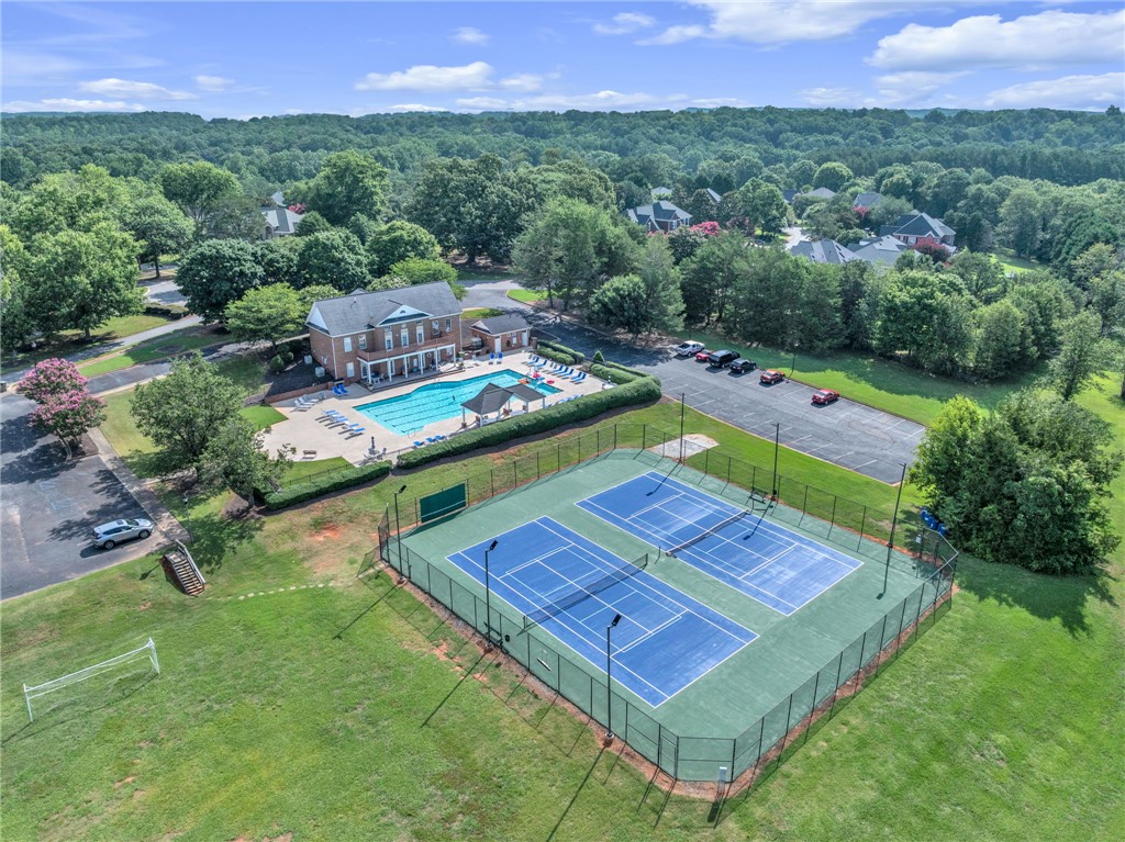 102 Country Walk Lane Clemson, SC 29631 - Photo 35 of 39 An aerial perspective reveals a community clubhouse, sparkling pool, and well-maintained tennis courts nestled among verdant trees.