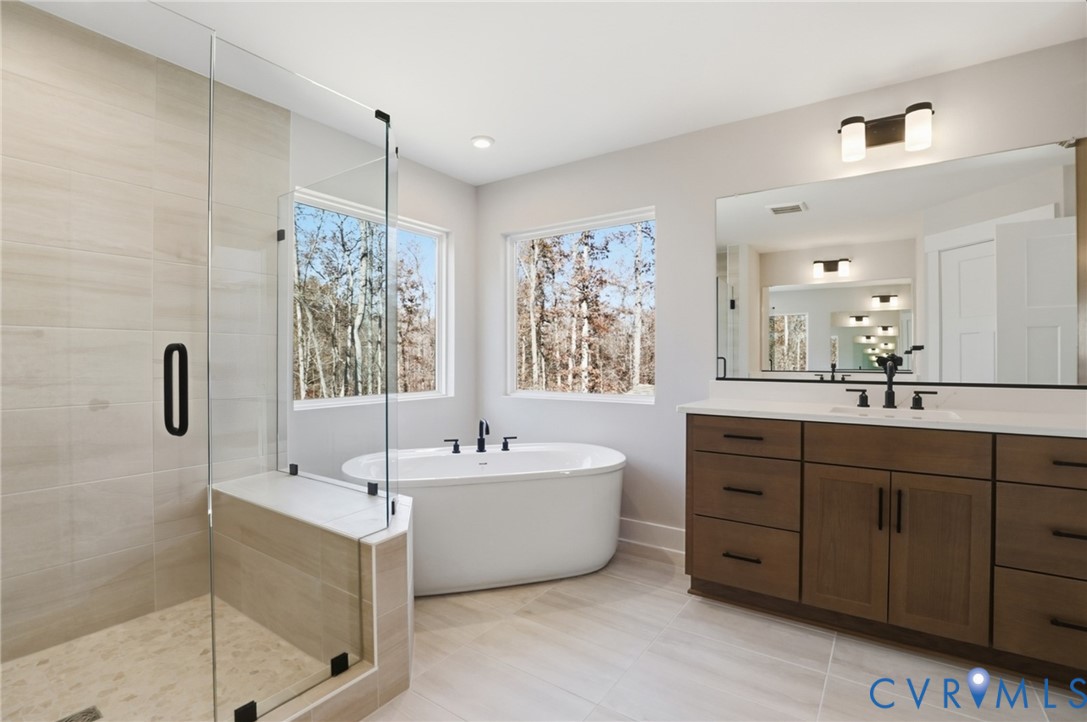 12420 Coalboro Road Chesterfield, VA 23838 - Photo 13 of 19 a spacious bathroom with a double vanity sink large mirror and a bathtub