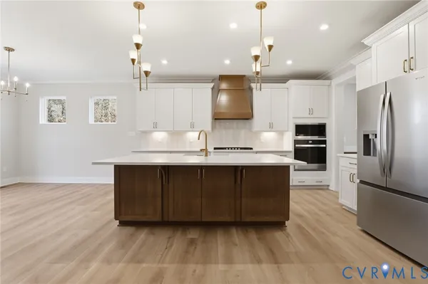 a kitchen with kitchen island a counter top space stainless steel appliances and cabinets
