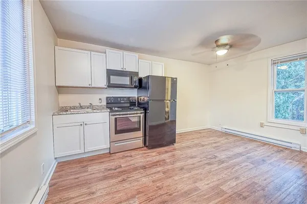 a kitchen with granite countertop white cabinets and stainless steel appliances