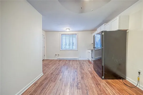 a view of empty room with wooden floor and window