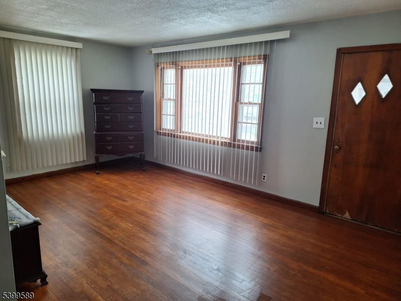 502 Drake Avenue Roselle, NJ 07203 - Photo 3 of 21 an empty room with wooden floor and windows
