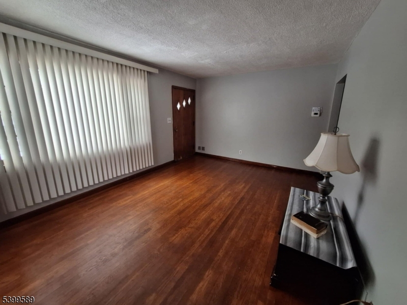502 Drake Avenue Roselle, NJ 07203 - Photo 4 of 21 a view of an empty room with wooden floor and a window