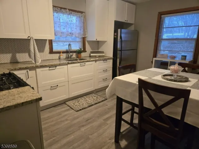 a kitchen with a table chairs refrigerator and cabinets