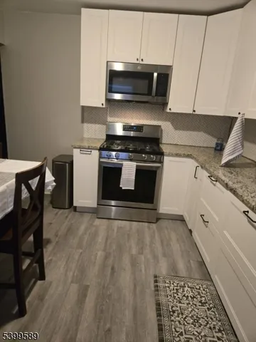 a kitchen with granite countertop a stove and a microwave