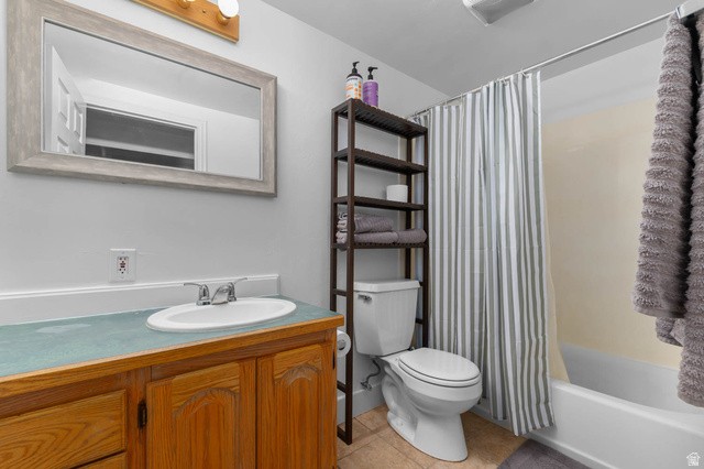 9902 South Poppy Lane Sandy, UT 84094 - Photo 14 of 25 Bathroom featuring a wood-finish vanity with an oval sink, a light-colored countertop, and a framed mirror
