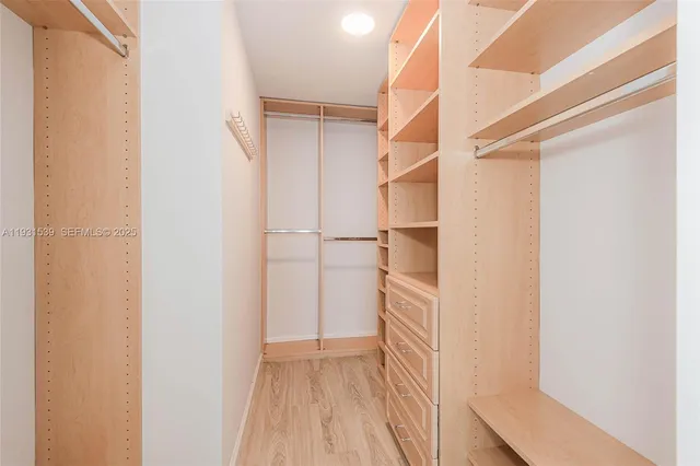 a view of walk in closet with empty racks