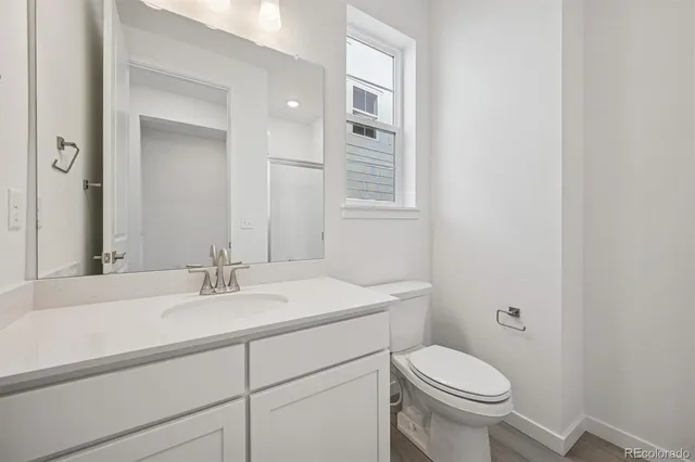 a bathroom with a sink toilet vanity and mirror