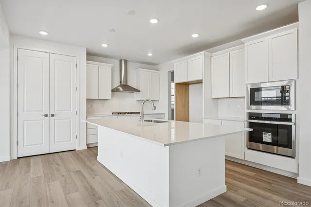 a kitchen with kitchen island white cabinets and stainless steel appliances