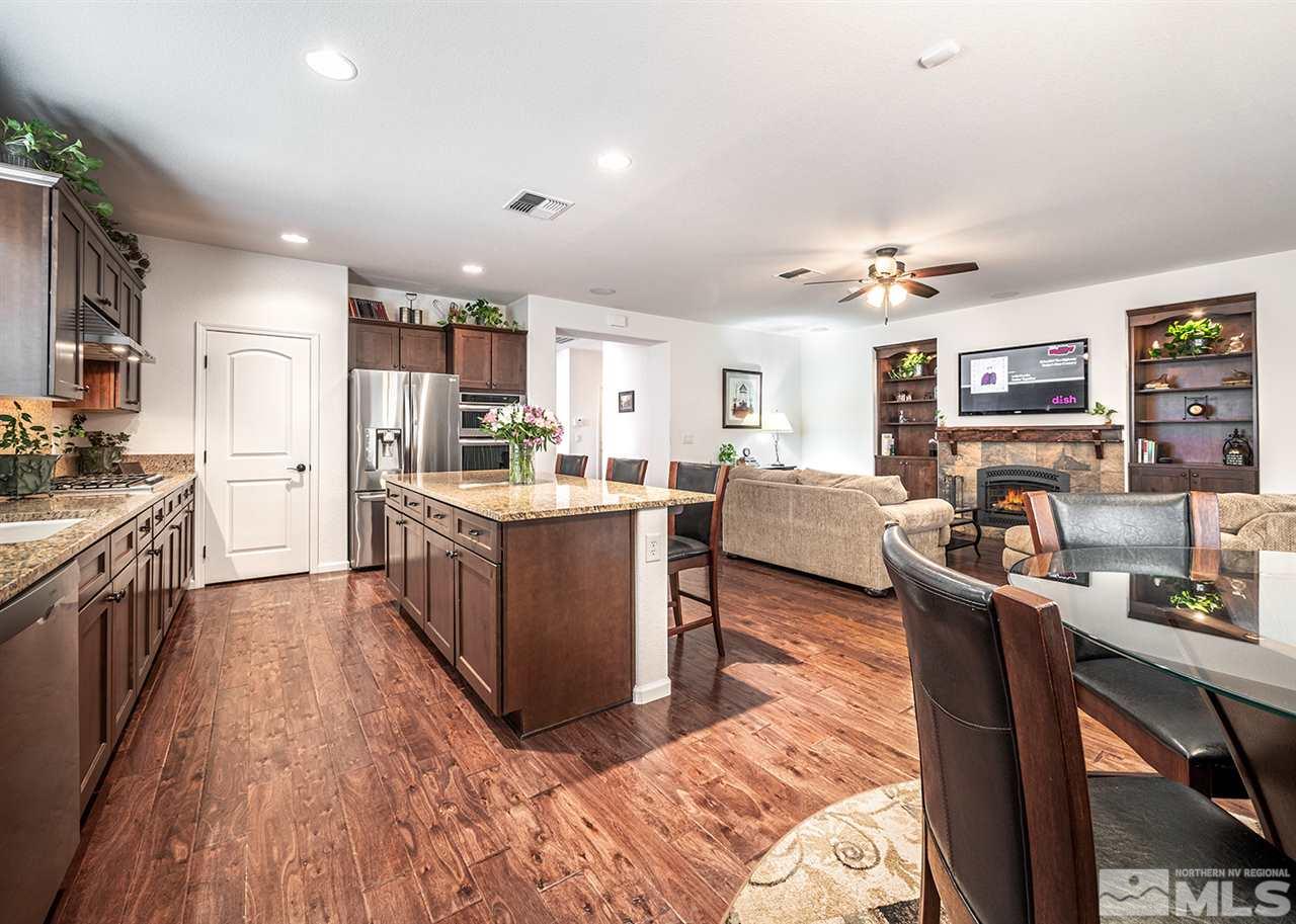 1640 Elk Run Trail Reno, NV 89523 - Photo 22 of 40 a kitchen with stainless steel appliances kitchen island granite countertop a stove top oven a sink dishwasher a dining table and chairs with wooden floor