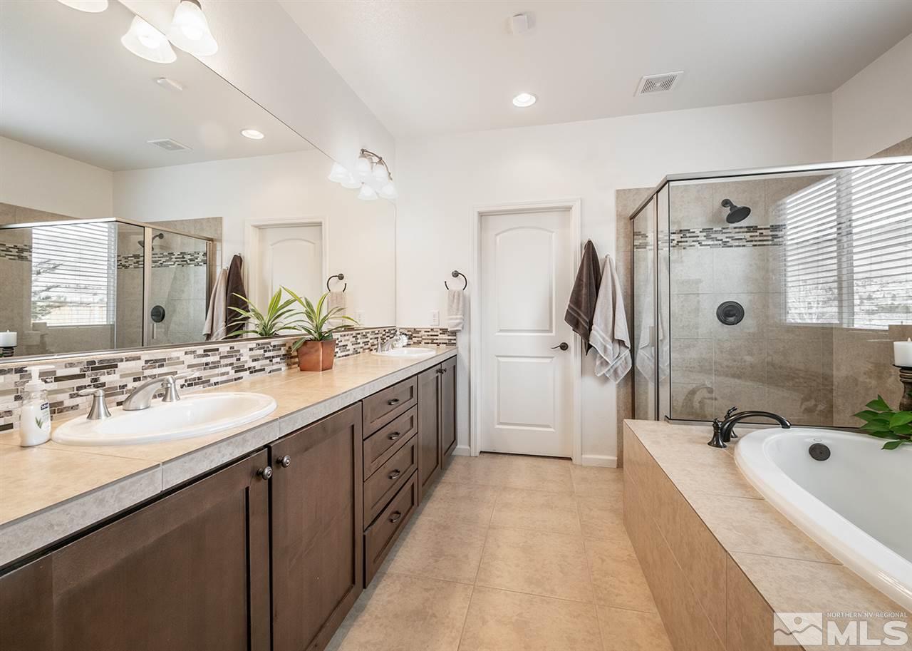 1640 Elk Run Trail Reno, NV 89523 - Photo 26 of 40 a bathroom with a granite countertop double vanity sink a mirror a bathtub and shower