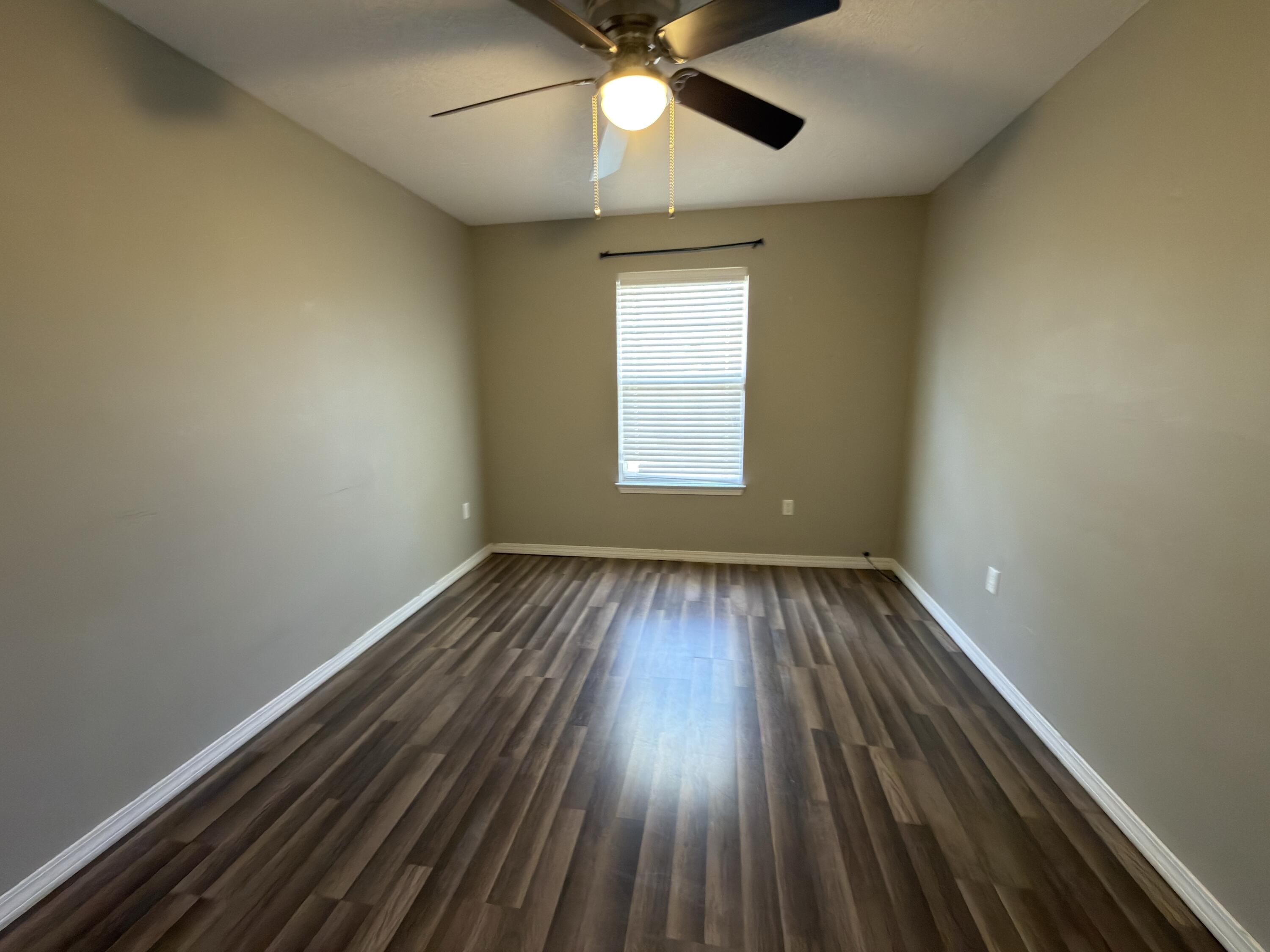 2673 Paddock Circle Crestview, FL 32536 - Photo 12 of 26 wooden floor in an empty room with a window