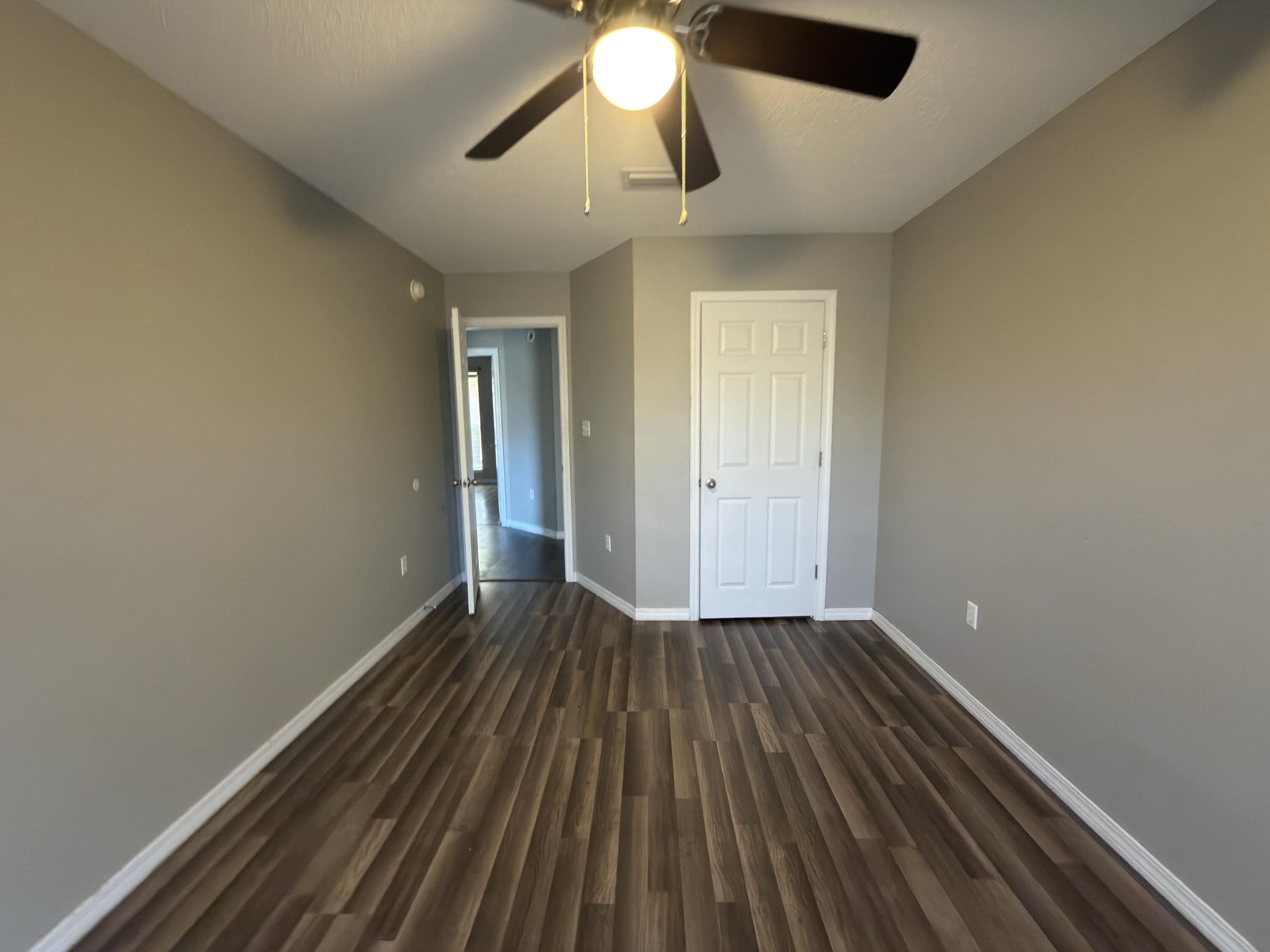 2673 Paddock Circle Crestview, FL 32536 - Photo 13 of 26 wooden floor in an empty room with a window