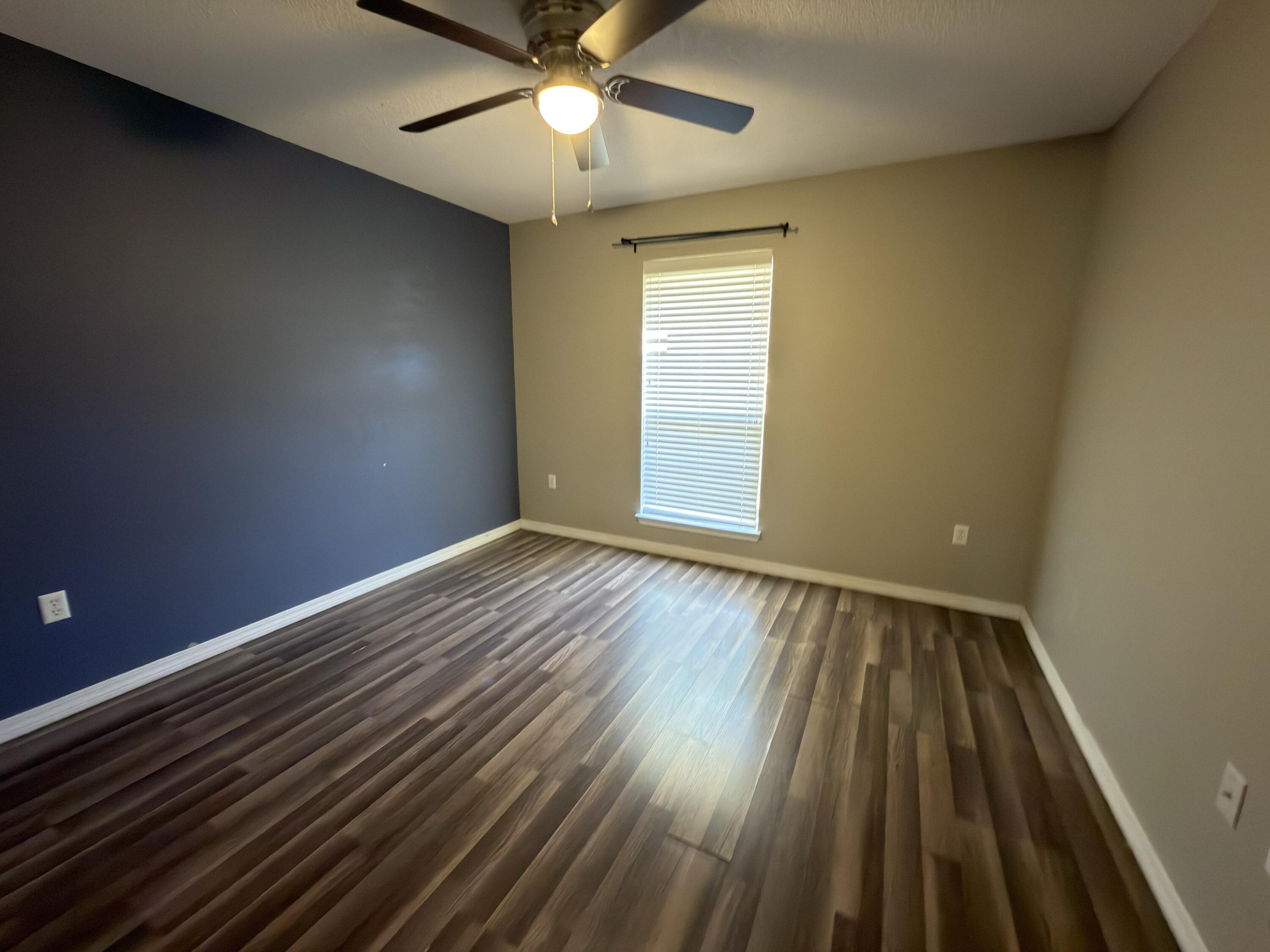 2673 Paddock Circle Crestview, FL 32536 - Photo 14 of 26 wooden floor in an empty room with a window