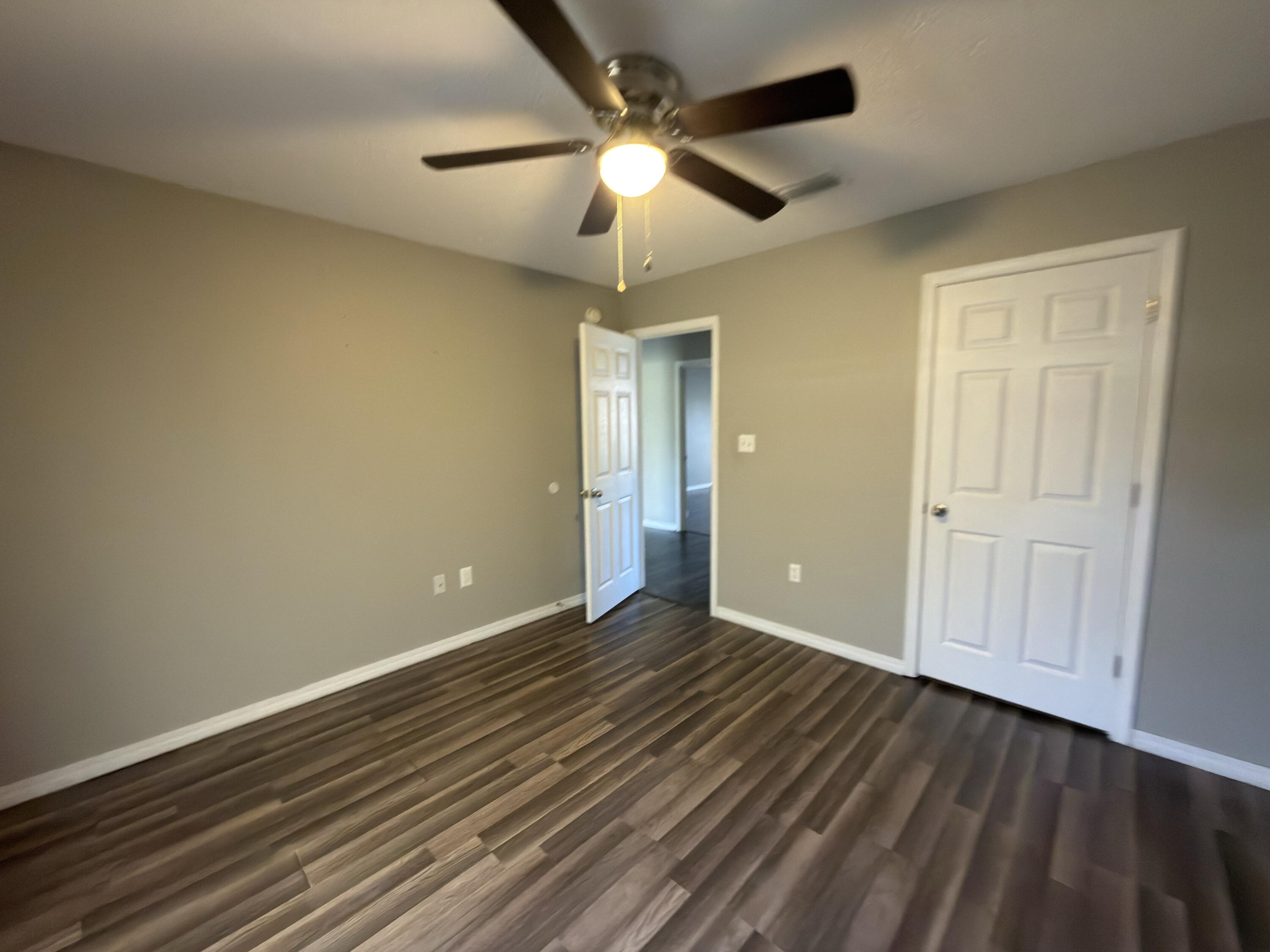 2673 Paddock Circle Crestview, FL 32536 - Photo 15 of 26 wooden floor in an empty room with a chandelier fan
