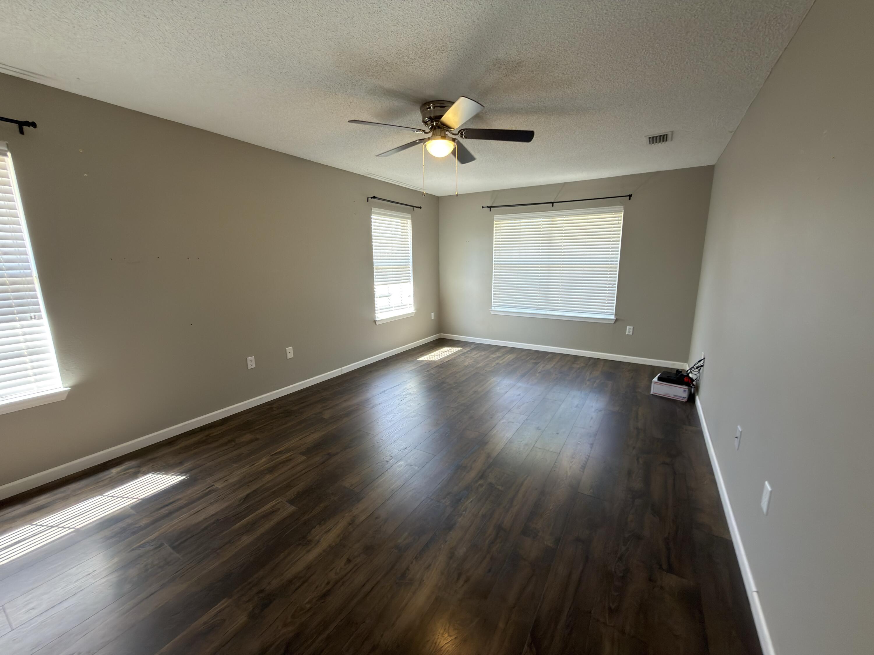 2673 Paddock Circle Crestview, FL 32536 - Photo 6 of 26 a view of an empty room with wooden floor and a window