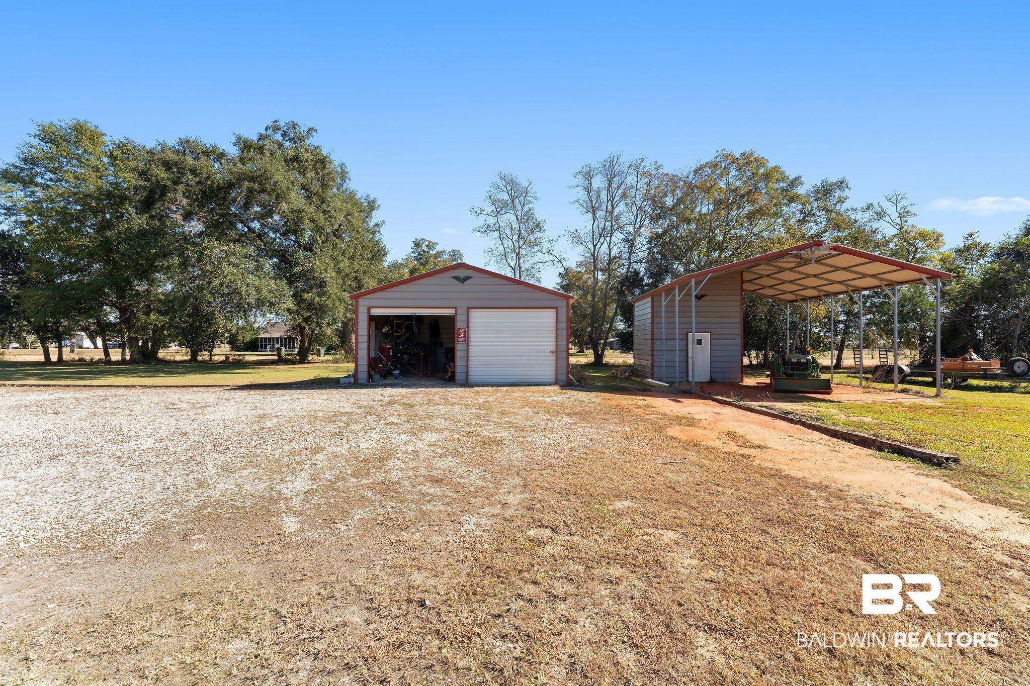 28980 Comstock Road Elberta, AL 36530 - Photo 27 of 38 View of side of home with an outdoor structure, a garage, a lawn, and driveway