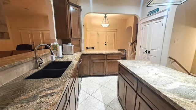 a kitchen with granite countertop a sink stove and cabinets