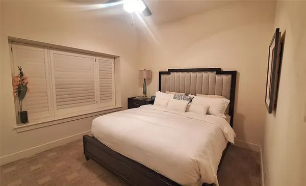 a large bed sitting in a bedroom next to a window