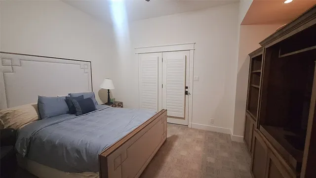 a bedroom with a bed and a refrigerator