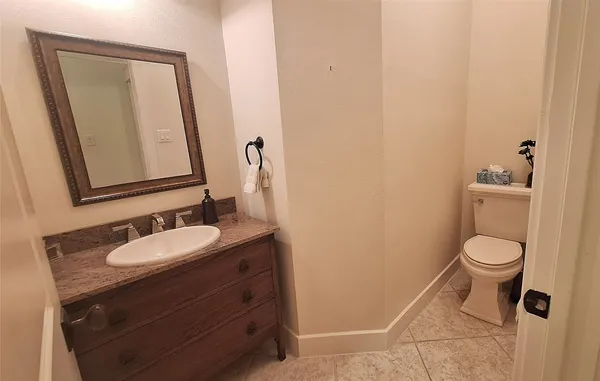 a bathroom with a granite countertop toilet sink and mirror