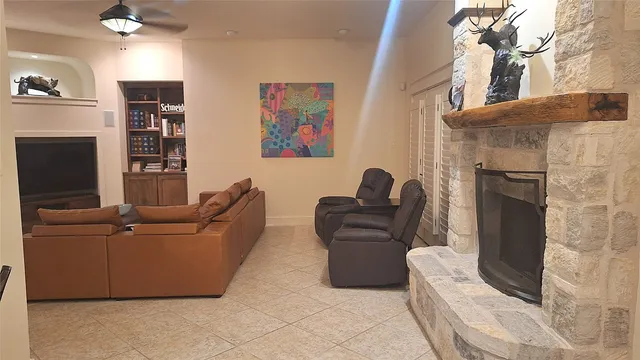 a living room with furniture a flat screen tv and a fireplace