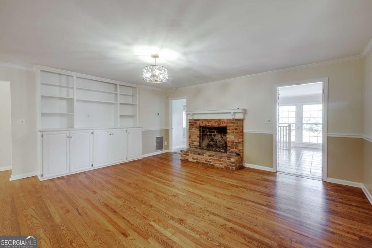 206 Fortson Drive Athens, GA 30606 - Photo 13 of 38 an empty room with wooden floor fireplace and windows