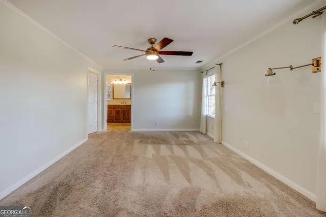a view of a big room with a chandelier fan and windows
