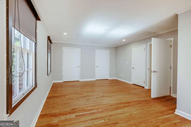 a view of empty room with wooden floor and windows