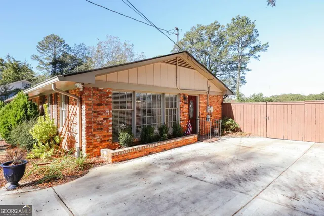 a view of backyard with small garden and wooden fence