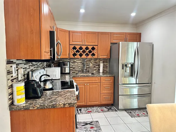 a kitchen with stainless steel appliances granite countertop a refrigerator and a sink