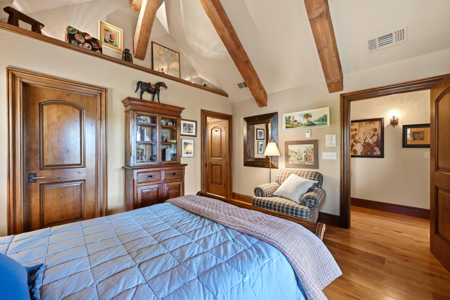 2581 Shirland Tract Road Auburn, CA 95603 - Photo 25 of 61 a bedroom with a large bed a chandelier and closet