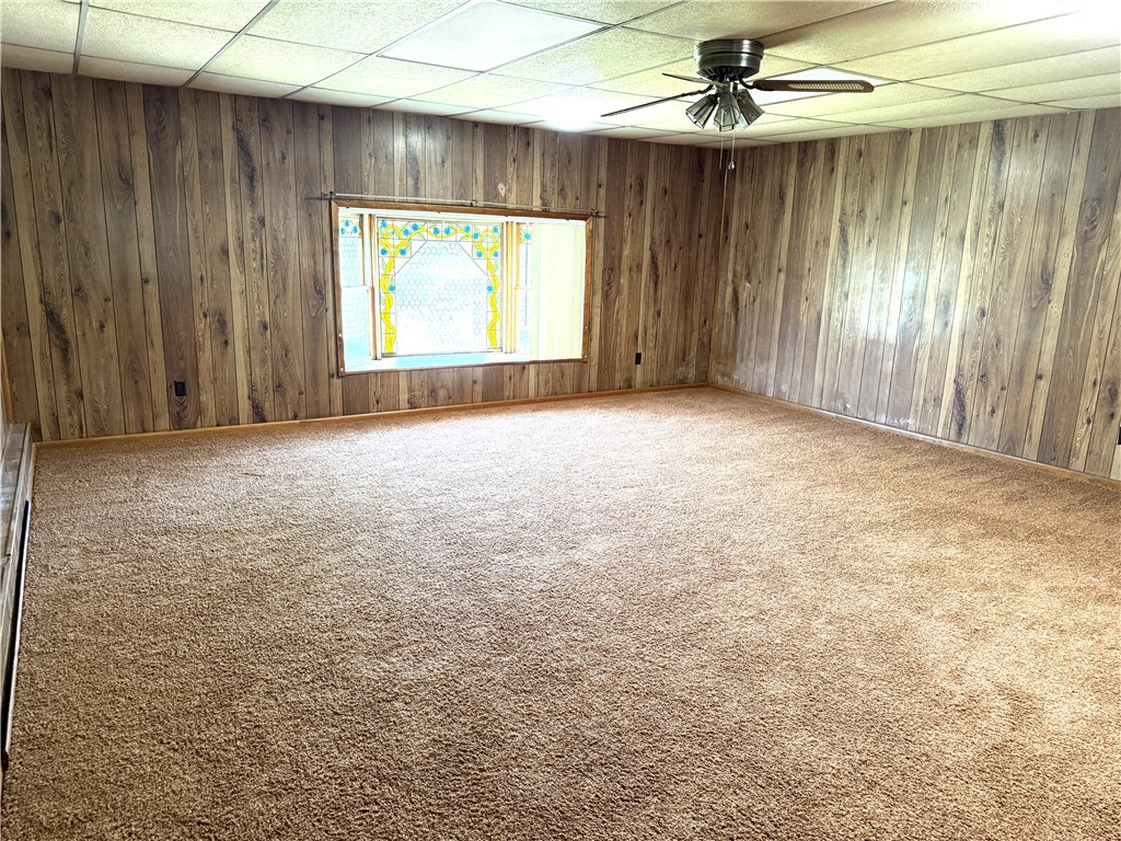 4732 Lehigh Drive Springfield, OH 45503 - Photo 16 of 27 This living area features rich wood paneling and soft carpeting, offering a cozy ambiance.