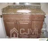 a bathroom with a granite countertop sink and a mirror
